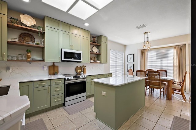 kitchen with white microwave, electric range, green cabinets, and open shelves