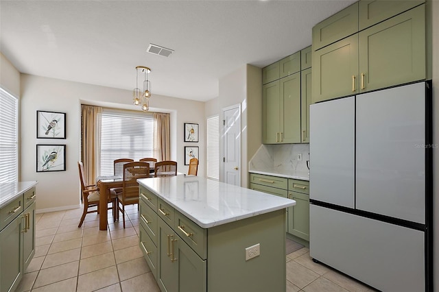 kitchen featuring refrigerator, light tile patterned flooring, visible vents, and green cabinetry