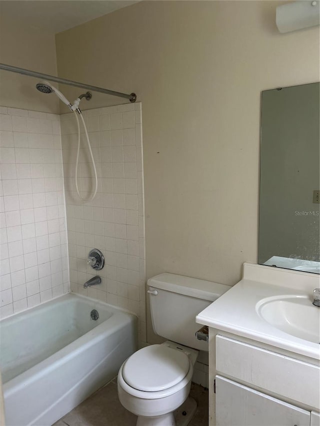 full bathroom with tiled shower / bath, vanity, toilet, and tile patterned floors