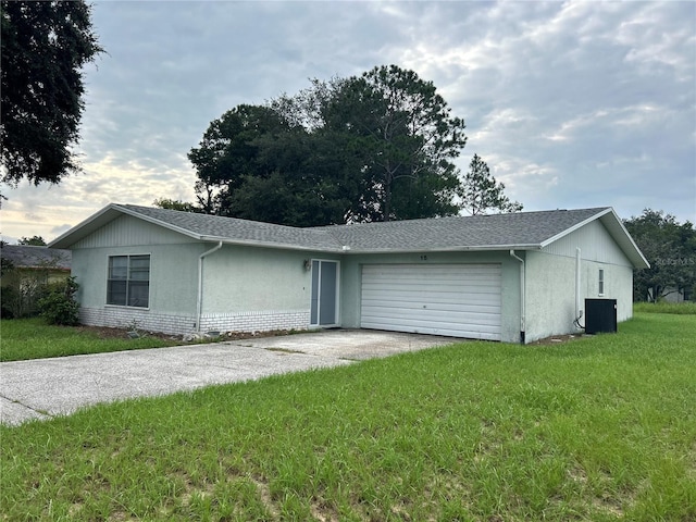 single story home with cooling unit, a garage, and a front yard