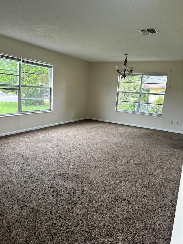 unfurnished room with a textured ceiling and carpet flooring