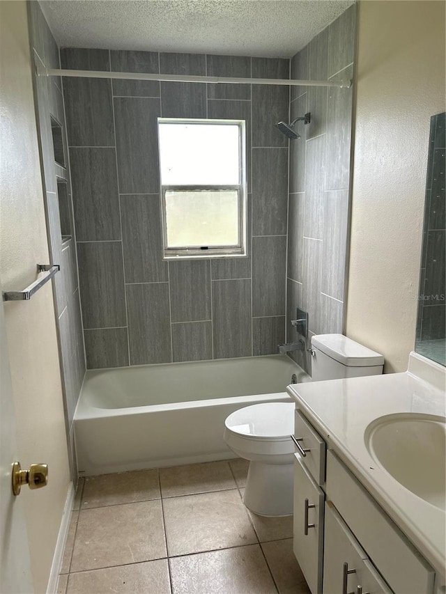 full bathroom featuring tile patterned floors, toilet, tiled shower / bath, a textured ceiling, and vanity