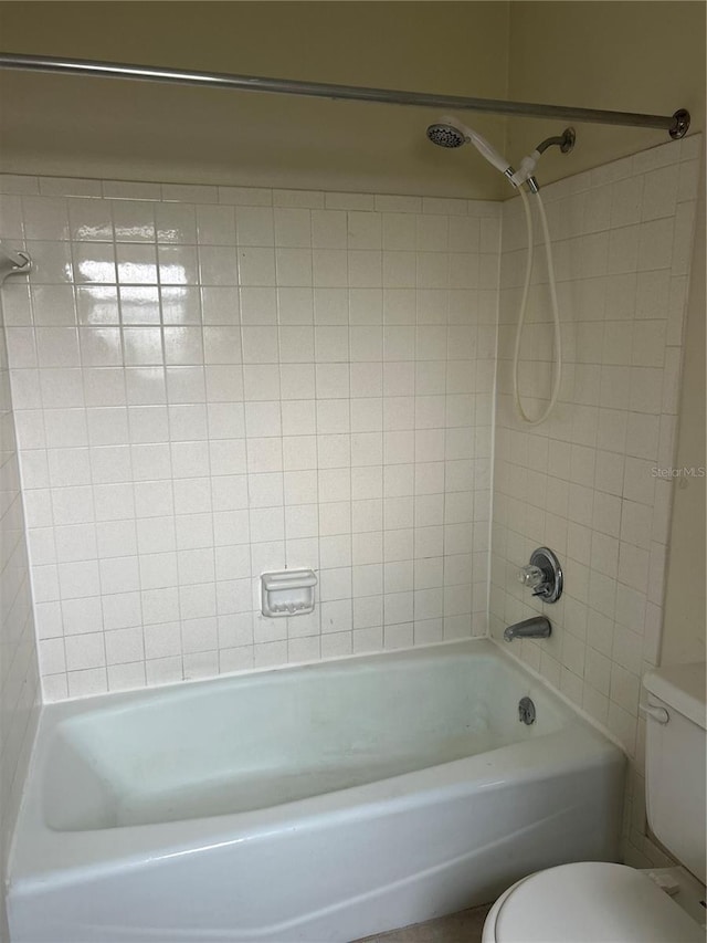 bathroom featuring tiled shower / bath and toilet