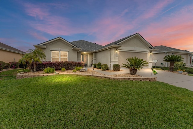 ranch-style home featuring a garage, driveway, a lawn, and stucco siding