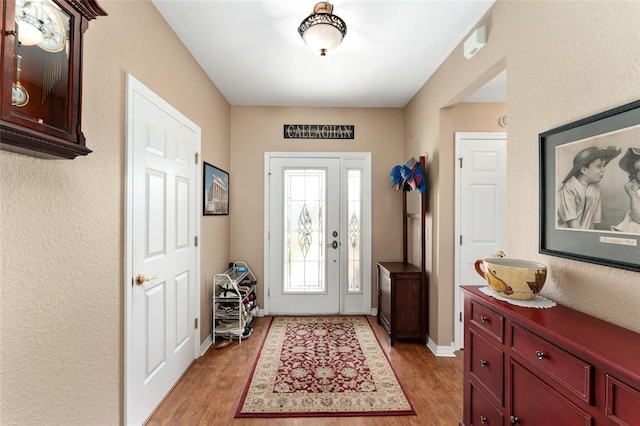 foyer entrance with light wood-type flooring and baseboards