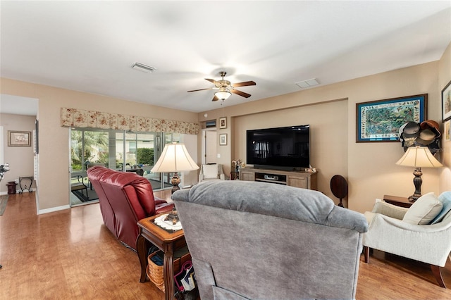 living room featuring light wood-type flooring, baseboards, visible vents, and a ceiling fan