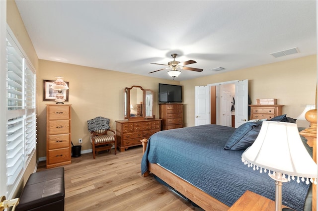 bedroom with a ceiling fan, light wood-style flooring, visible vents, and baseboards