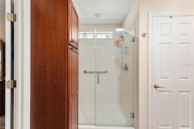 bathroom featuring a shower stall and a textured ceiling