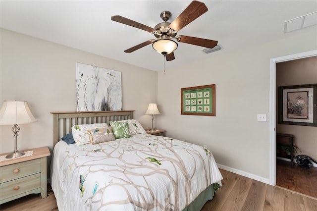 bedroom featuring visible vents, ceiling fan, baseboards, and wood finished floors