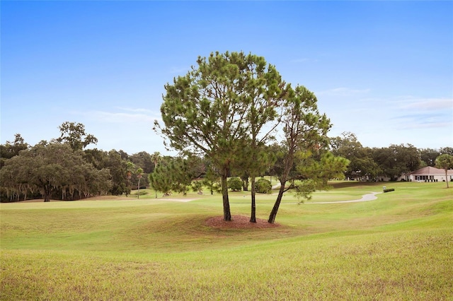 view of home's community with view of golf course and a lawn