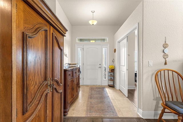 tiled foyer entrance featuring a textured ceiling