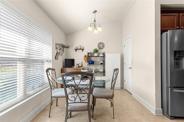 dining area featuring an inviting chandelier and lofted ceiling