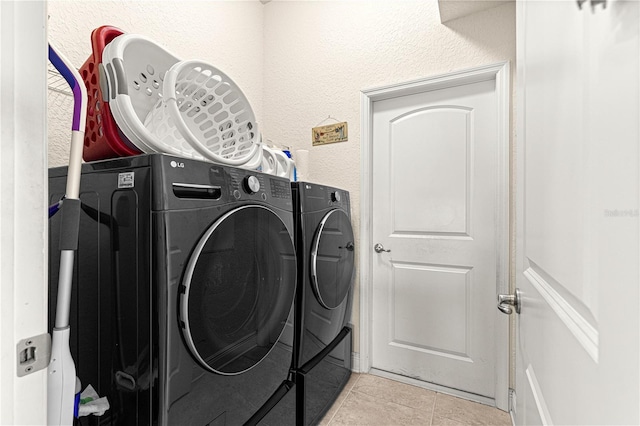 laundry area with separate washer and dryer and light tile patterned flooring