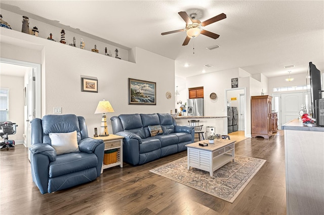 living room with dark hardwood / wood-style floors, a textured ceiling, and ceiling fan