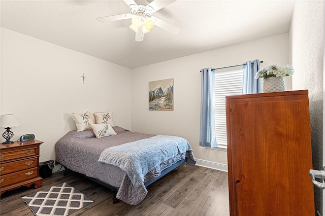 bedroom with ceiling fan and dark hardwood / wood-style flooring