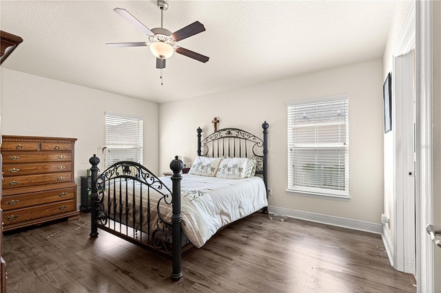 bedroom with ceiling fan, a textured ceiling, and dark hardwood / wood-style flooring