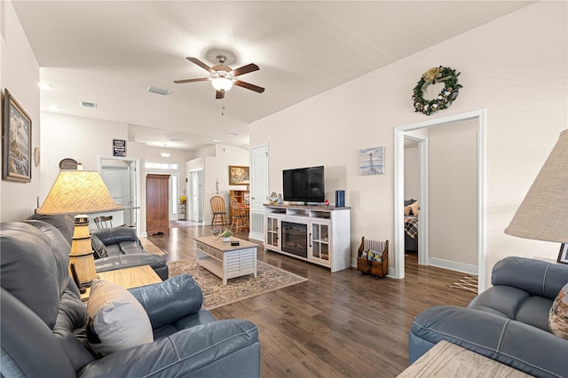 living room with dark wood-type flooring and ceiling fan