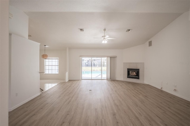 unfurnished living room featuring hardwood / wood-style flooring, a fireplace, high vaulted ceiling, and ceiling fan