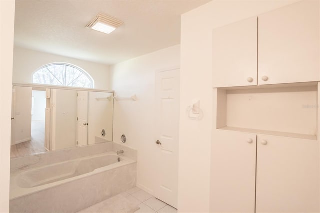 bathroom with tile patterned flooring and a bathtub