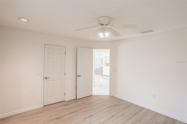 empty room with ceiling fan and light wood-type flooring