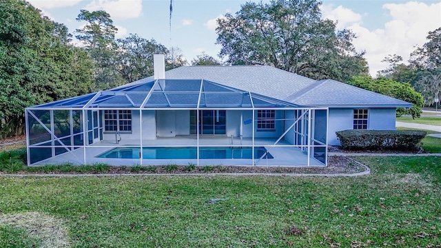 rear view of property with a yard, glass enclosure, and a patio area