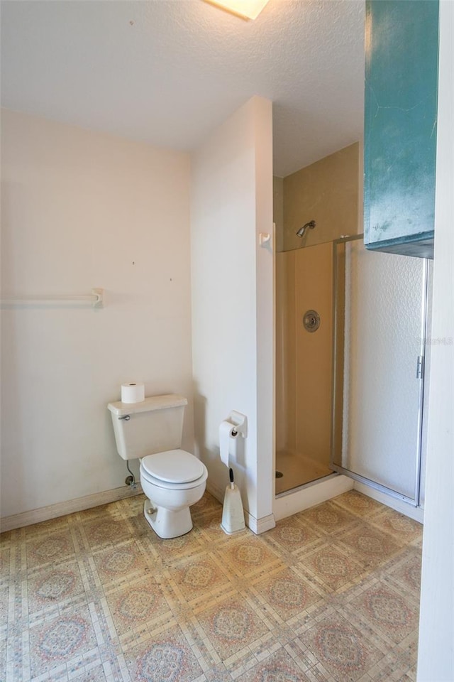 bathroom featuring toilet, an enclosed shower, and a textured ceiling