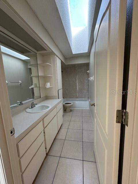 full bathroom with vanity, toilet, tiled shower / bath combo, and tile patterned flooring