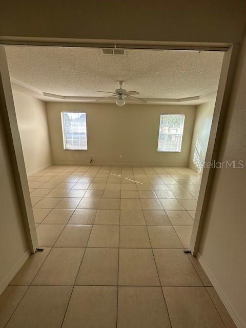 tiled spare room featuring ceiling fan and a textured ceiling