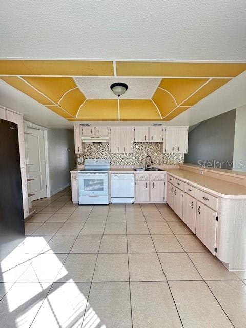 kitchen with sink, light tile patterned floors, white appliances, and decorative backsplash