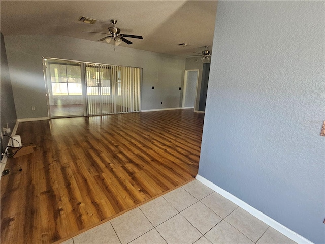 empty room with ceiling fan, baseboards, wood finished floors, and visible vents