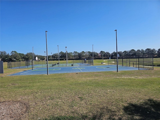 view of basketball court with fence, community basketball court, and a yard