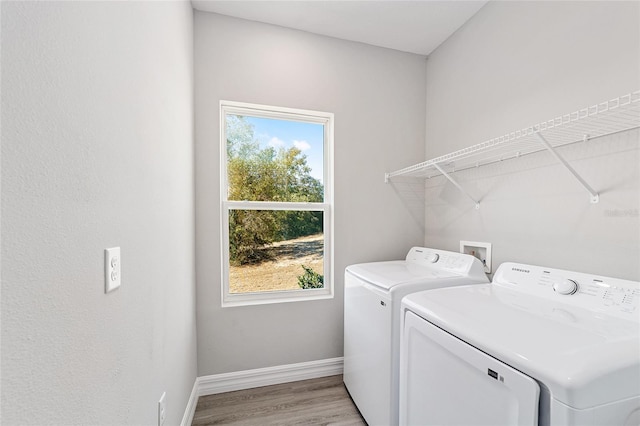 laundry area with light hardwood / wood-style flooring and independent washer and dryer