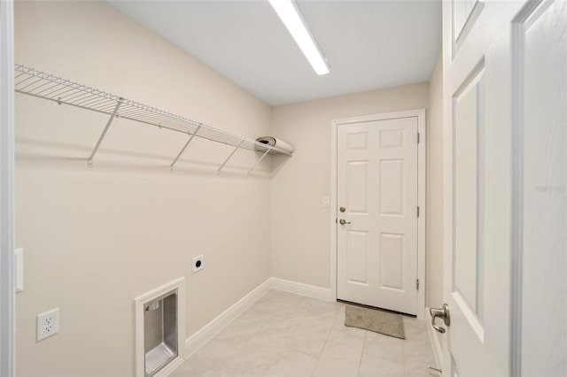 washroom with electric dryer hookup and light tile patterned floors