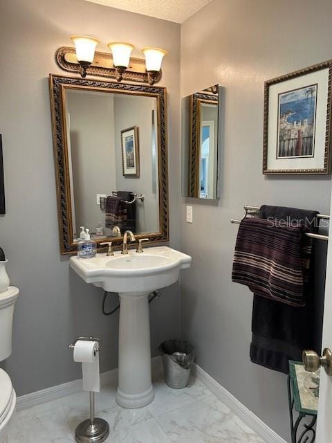 bathroom featuring toilet and a textured ceiling