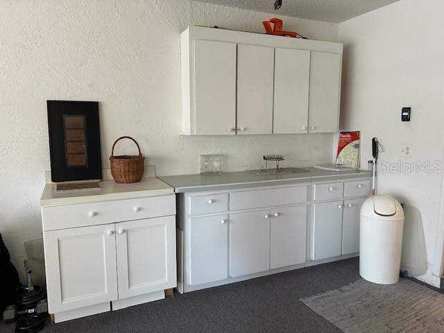 kitchen featuring white cabinetry and sink