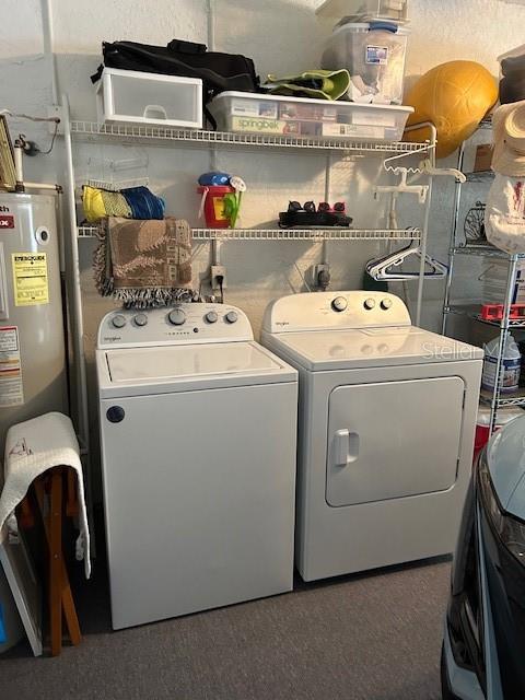 washroom with washing machine and dryer and water heater