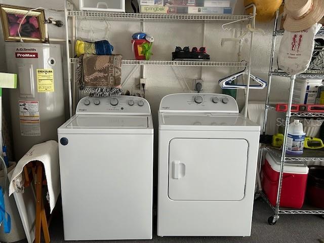 washroom featuring electric water heater and washing machine and clothes dryer