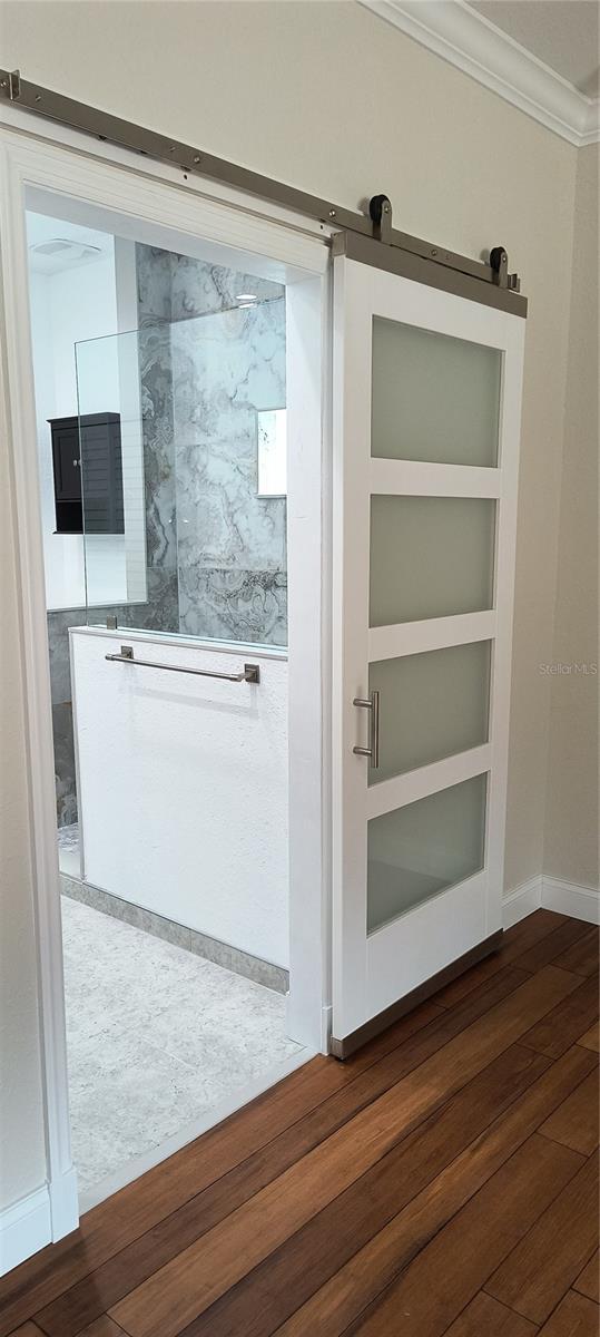 interior space with ornamental molding and wood-type flooring