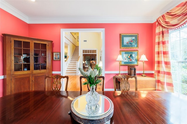 dining space featuring hardwood / wood-style floors and ornamental molding