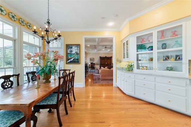 dining room featuring coffered ceiling, crown molding, a chandelier, light hardwood / wood-style flooring, and beamed ceiling