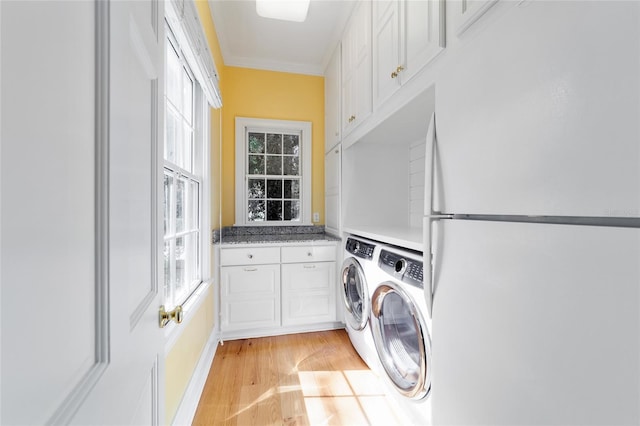 laundry room featuring cabinets, light hardwood / wood-style flooring, ornamental molding, and independent washer and dryer