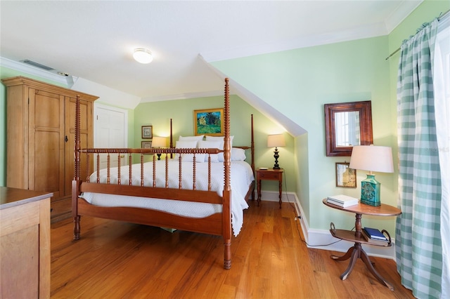 bedroom featuring crown molding and light wood-type flooring