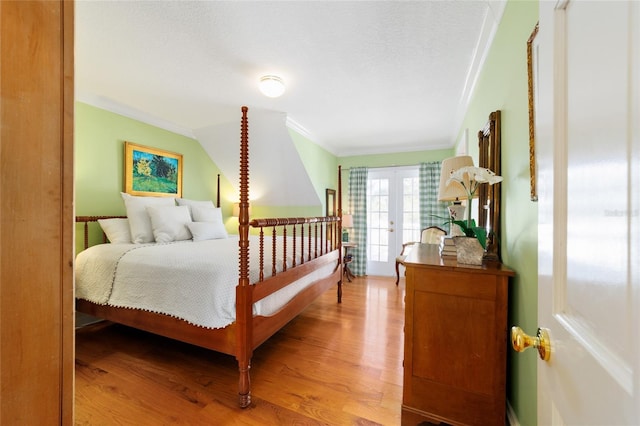 bedroom featuring french doors, crown molding, and light hardwood / wood-style floors