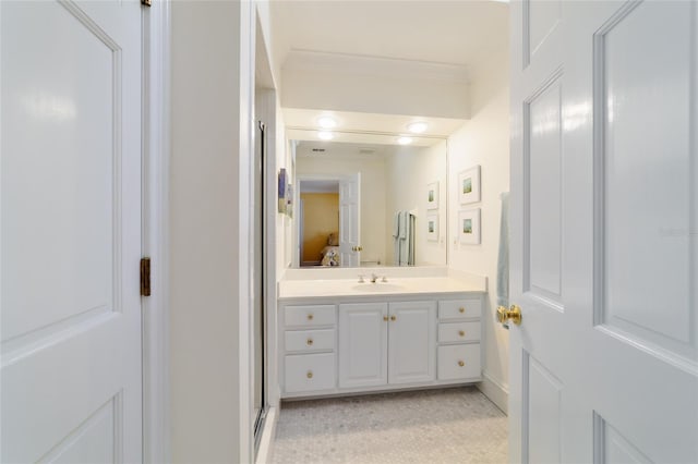 bathroom with ornamental molding, vanity, and walk in shower