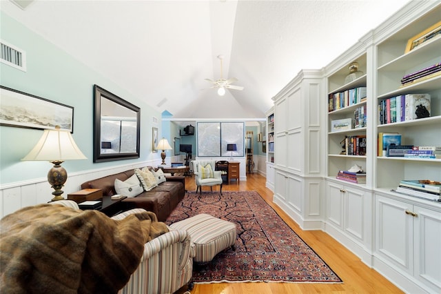 living room featuring vaulted ceiling, ceiling fan, and light wood-type flooring