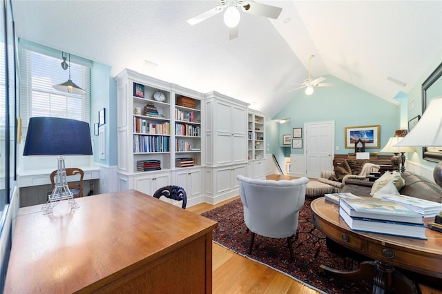 office area featuring ceiling fan, lofted ceiling, a textured ceiling, and light wood-type flooring