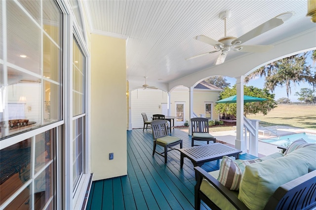 sunroom featuring ceiling fan and ornate columns