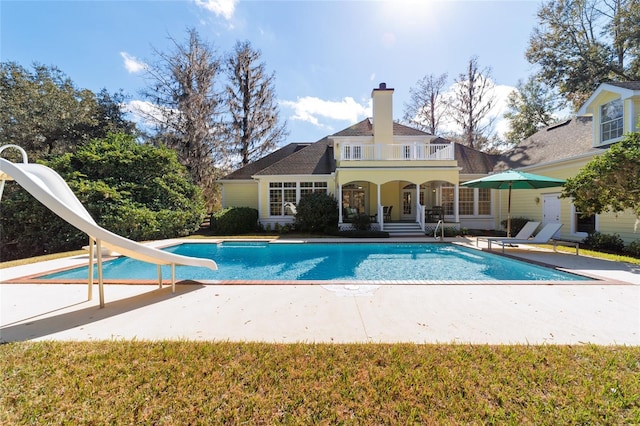 view of swimming pool with a patio and a water slide