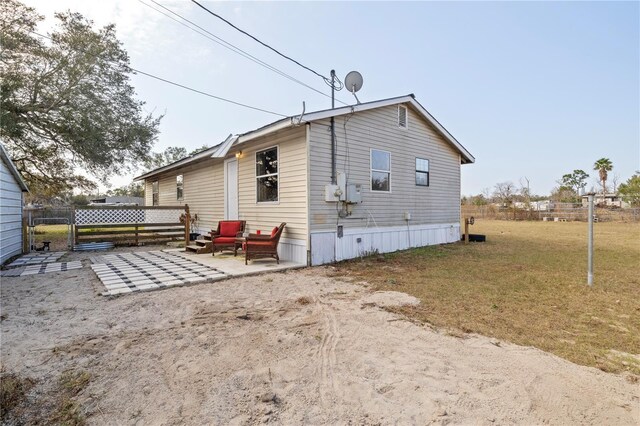 rear view of house with an outdoor hangout area, a lawn, and a patio area