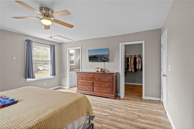 bedroom featuring ensuite bathroom, a spacious closet, light wood-type flooring, a closet, and ceiling fan